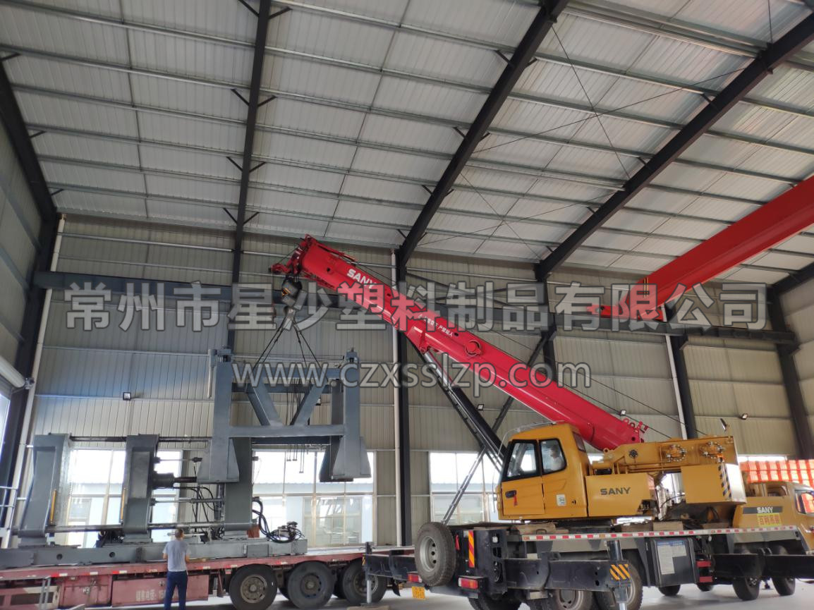 工作人員合作無間，正在進行吹塑機卸車工作。